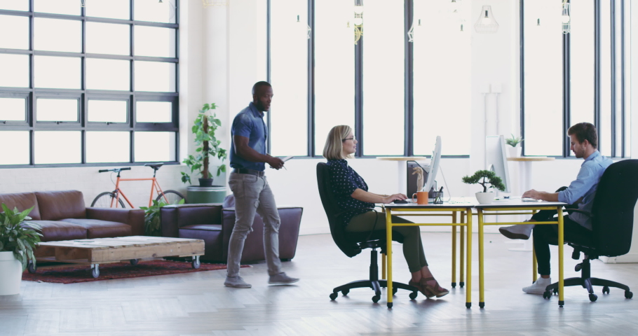 They work seamlessly together. 4K video footage of a diverse group businesspeople working together in a modern office.