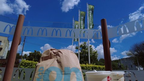 Warsaw, Poland, June 21, 2022: McDonalds' restaurant. Flags and glass. Meal on the table. Rare short with camera going from upper level to lower. Unhealthy food, fast food. 