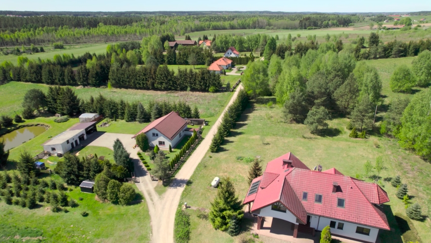 Aerial View of Houses and Surrounding From Green Poland Village. Aerial View Countryside Road Between Trees and Houses. Charming Small Europe Village Scene in Poland, Road and Farm.