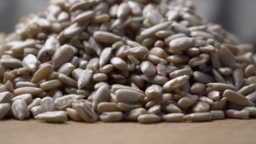 Peeled sunflower seeds on a rotating wooden surface, close-up video. Sunflower seeds, highly detailed macro video 4k.