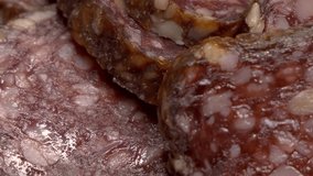 Pieces of smoked salami, macro video. Sausage. Sliding shot, full frame.