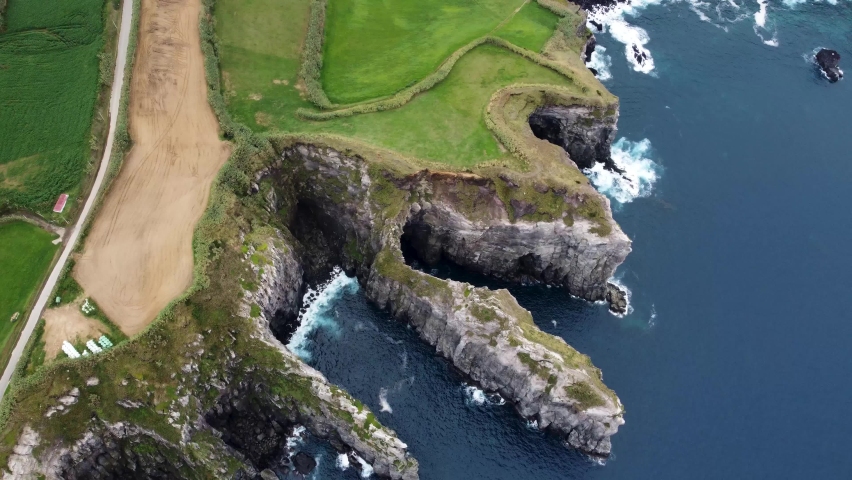 Top aerial view of cliff coastline in Azores island. Rocks of San Miguel Azores island. Aerial view of Atlantic ocean coastline 4k. Royalty-Free Stock Footage #1091527573