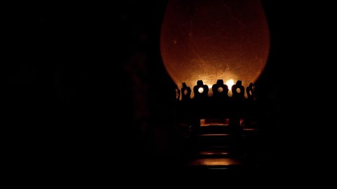 A kerosene lamp burns in the dark