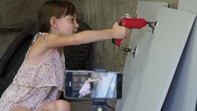 A child blogger explains to subscribers how to use an electric screwdriver. Workshop in the garage. Social media concept.