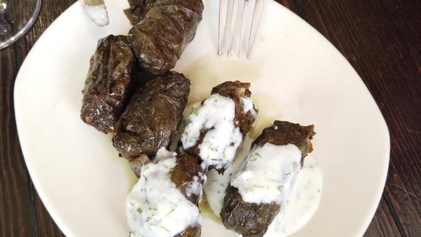 Dolma in marinated grape leaves, eaten with a fork, top view. | Shutterstock HD Video #1091530979