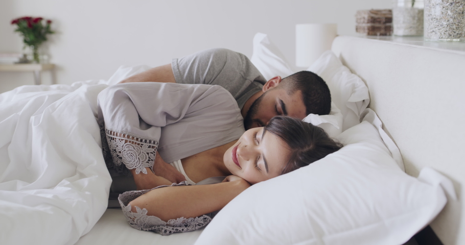 Young couple napping in a bed at home. Latin boyfriend and girlfriend sleeping together. Happy woman cuddling with her boyfriend. Husband and wife waking up in the morning. A cosy young couple in bed | Shutterstock HD Video #1091532683