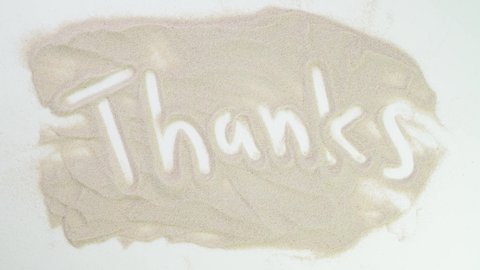 thank you, thanks Top view draw on the sand. Caucasian hands write text in beige sand. Vacation and travel. Beach on vacation. Sand painting. Creativity from natural materials.