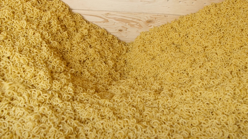 Industrial line for the production of pasta. Vermicelli spilling. Factory for the production of macaroni. Food background for restaurants or cafes, for brand advertise.