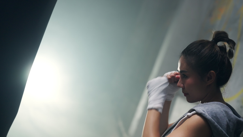 4K Healthy and strong Asian woman athlete do sport training workout boxing exercise with punching bag in abandoned building. Active female boxer practicing fighting exercise kickboxing in dark place
 Royalty-Free Stock Footage #1091540103