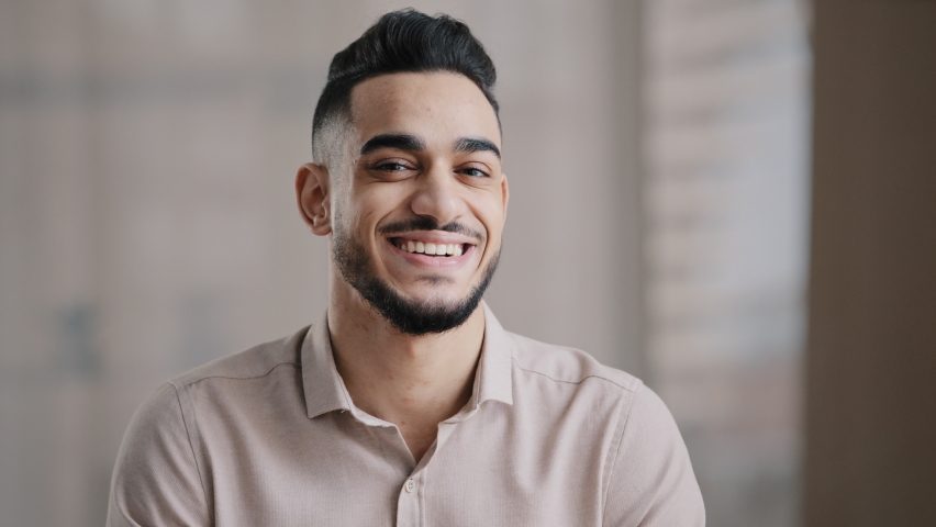 Portrait of confident calm young man arabic ethnic male handsome brunet guy turn head at camera happy male human bearded face positive smiling hispanic millennial businessman shows toothy health smile Royalty-Free Stock Footage #1091540683
