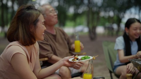 Asian family happy with Bar-B-Q time. Medium family travel together on holiday weekend. best vacation kids happy with family spending time together doing grill BBQ on beach campfire camping.