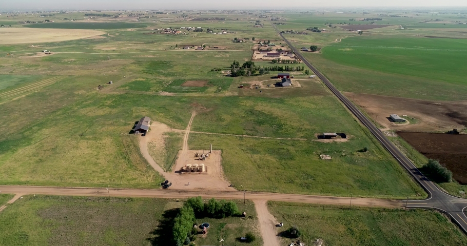 Birdseye perspective on an early morning during the beginning of summer over ranch properties in northern Colorado. Drone 4k. Weld County June 2022.