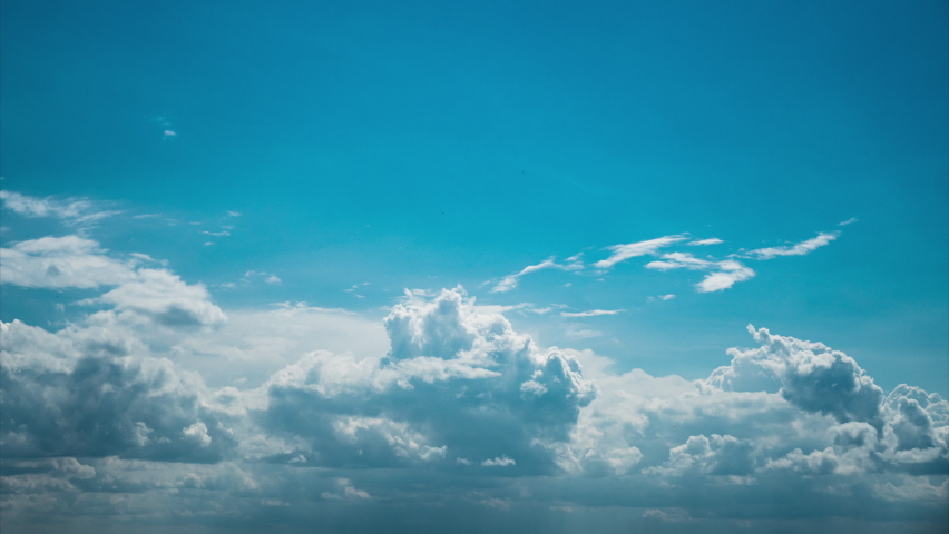 White fluffy clouds slowly float through the blue daytime sky timelapse. Beautiful skies are moving. Airy snow-white clouds move to the side. Royalty-Free Stock Footage #1091551161