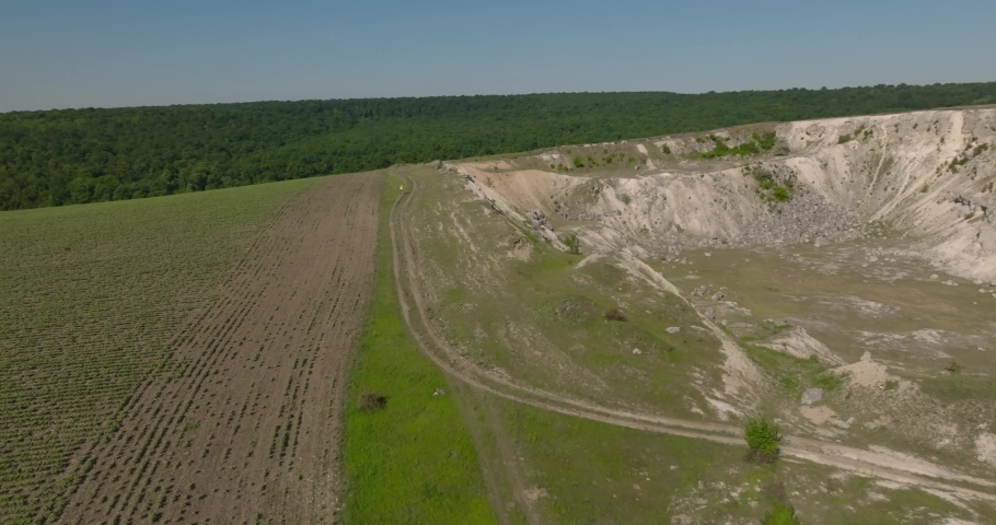 people running on the edge of quarry with forrest on bakground