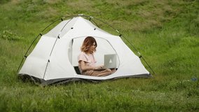a young woman is happy to communicate via video link through a laptop, on the mountain hills, work on vacation. rest of one person in nature, in the mountains. distant work.