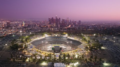 Cinematic Los Angeles downtown background at pink sunset. Dodgers Stadium illuminated at night panorama 4K aerial. Los Angeles city buildings skyline. Dodgers Stadium, Los Angeles, America June 2022