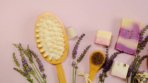 Lavender soap and truffles and bristle brushes and lavender flowers on a pink background.Cosmetic spa set with lavender extract. Lavender organic body cosmetics.