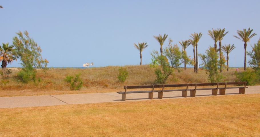 Empty Wooden Bench In The Promenade Overlooking The Blue Sea During Summer. - wide | Shutterstock HD Video #1091579019