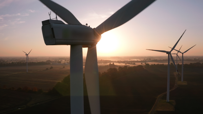 Close-up view windmill farm from drone. Cinematic aerial view of large wind turbines producing clean sustainable energy, clean energy future. Windmill farm in a field at sunrise with fog aerial view. Royalty-Free Stock Footage #1091582101