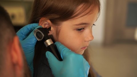 4k video close-up examination of childs ear with otoscope. Otoscopy. Visit to ENT doctor and consultation.