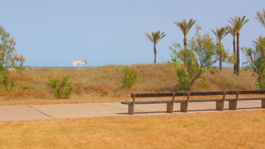 Empty Wooden Bench In The Promenade Overlooking The Blue Sea During Summer | Shutterstock HD Video #1091589517