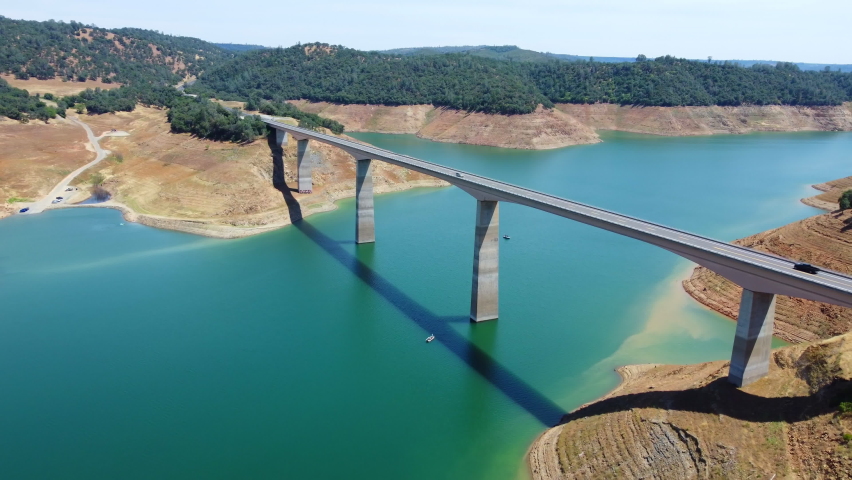 Aerial fly Calaveras County, California, now submerged beneath a reservoir named New Melones Lake. Flight over a large bridge over a reservoir in California National Park