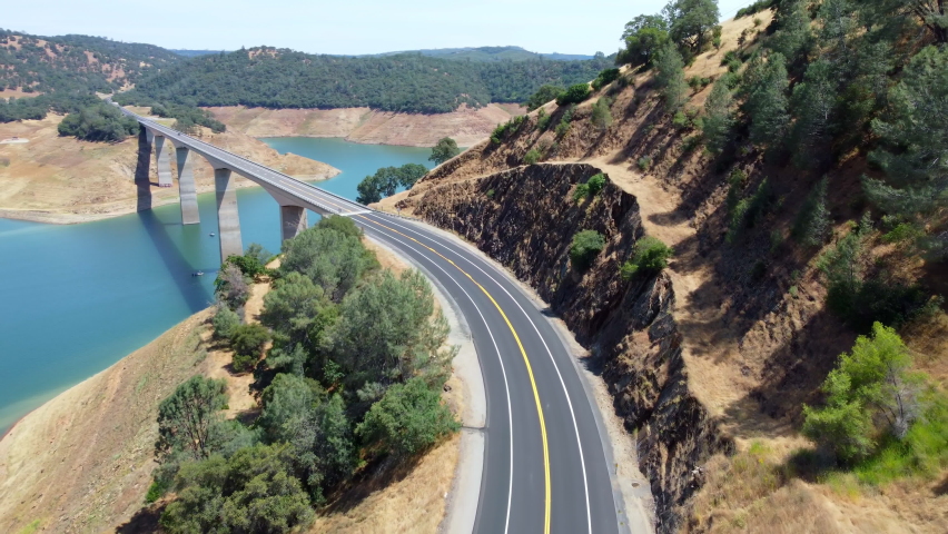 Aerial fly Calaveras County, California, now submerged beneath a reservoir named New Melones Lake. Flight over a large bridge over a reservoir in California National Park