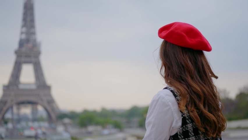 Cinematic footage of a young woman wearing fashionable clothes having fun in Paris at the eiffel tower park and streets. Concept about european tourism and travels to the capital cities | Shutterstock HD Video #1091594387