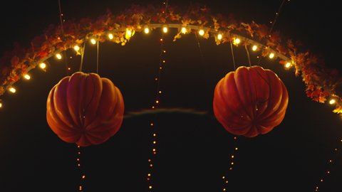 Halloween Pumpkin Lanterns in an Amusement Park Alley Glowing at Night. Halloween Decorations. Mystery Night Atmosphere. Handheld Shot.