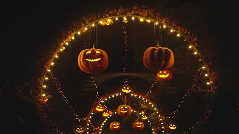 Halloween Pumpkin Lanterns in an Amusement Park Alley Glowing at Night. Halloween Decorations. Mystery Night Atmosphere
