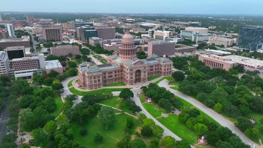 Wide aerial orbit of Texas State Capitol building in Austin, capital of TX. City panorama in beautiful light. Royalty-Free Stock Footage #1091599089