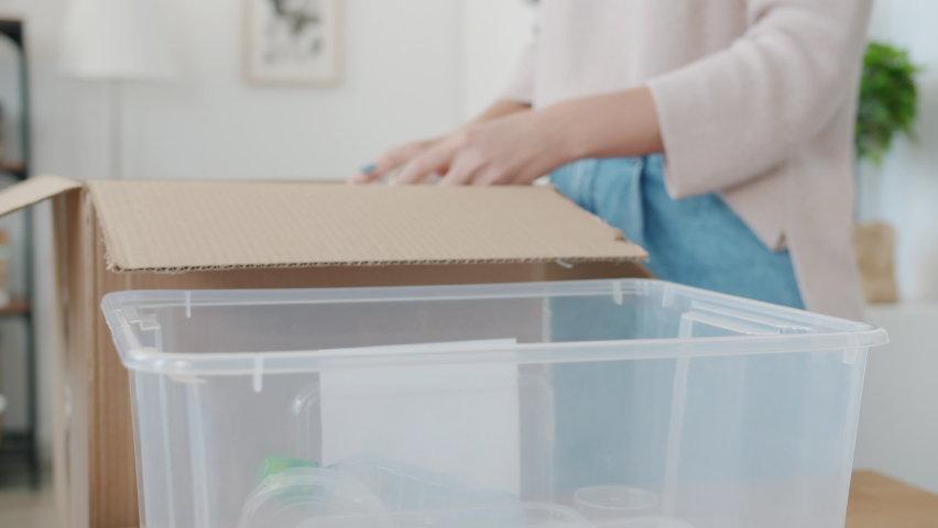 Close-up of female hand sorting out plastic trash putting packages in recycling container indoors at home. Environmental protection and ecology concept. | Shutterstock HD Video #1091600271