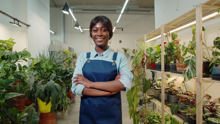 Florist African American woman portrait, flower shop. Greenhouse worker smiling, happy botanist close-up, small business owner. Gardener working in plant store. 