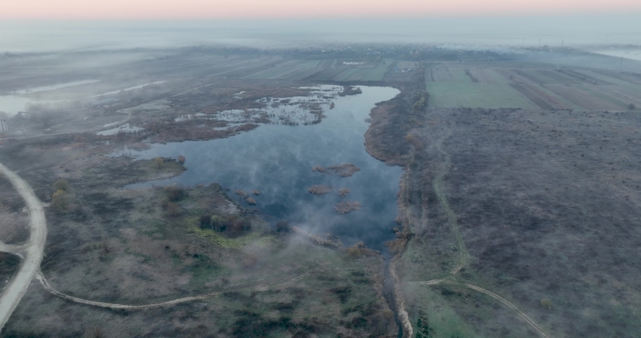 Beautiful lake in the middle of a land. Sunrise in the hills after a misty night
