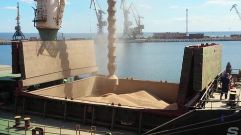 2021-06-09 Mariupol, Ukraine. Ukrtransagro LLC. Aerial of grain loading to bulker ship cargo hold at sea grain elevator in port. Wheat shipment from silo to bulk vessel via trunk at seaport terminal.