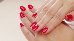 4K video of Female hands with fashionable manicure of red color . Woman shows her new red manicured nails, closeup. Beauty of nails. Classic red manicure. 