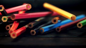 Colored pencils fall on a wooden table. Against a dark background. Filmed is slow motion 1000 fps. - Powered by Shutterstock - Get 15% off with code: PIKWIZARD15
