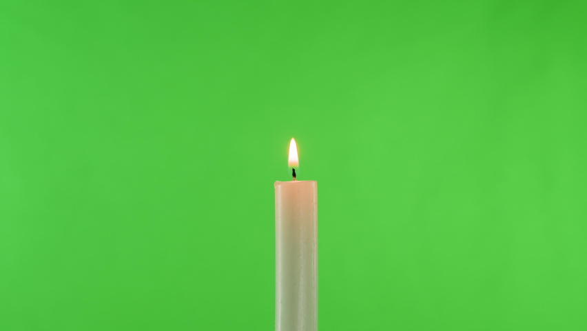 Burning wax candle on green chroma key background. Fire flame candlelight close-up. | Shutterstock HD Video #1091604667