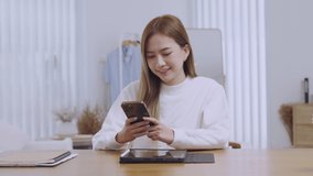 Asian girl using smart phone playing game and social media or chatting with her friends.