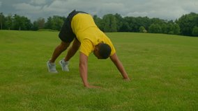 Motivated determined sporty fit African American man performing pike push up exercise, strengthening shoulder muscles and improving core stability while working out outdoors. - Powered by Shutterstock - Get 15% off with code: PIKWIZARD15