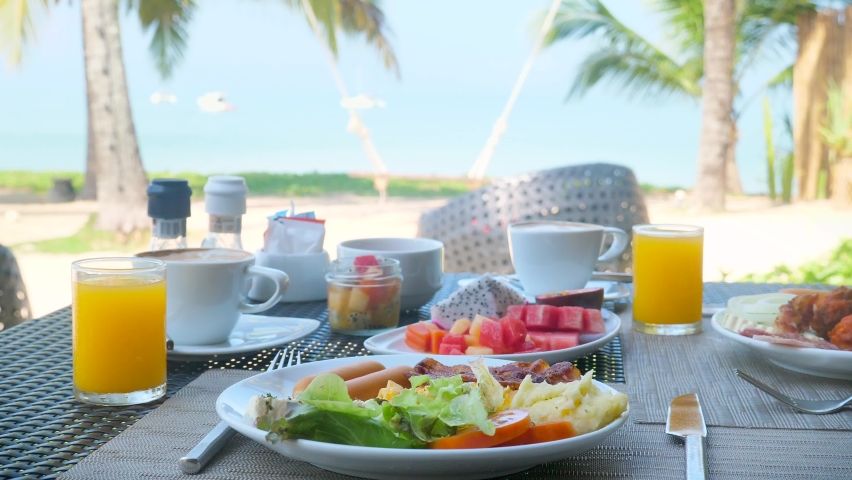 Luxury breakfast table with healthy food for two with beautiful tropical sea view and palm trees in background. Morning in hotel, summer holidays. Concept of travel, vacation on ocean | Shutterstock HD Video #1091609237