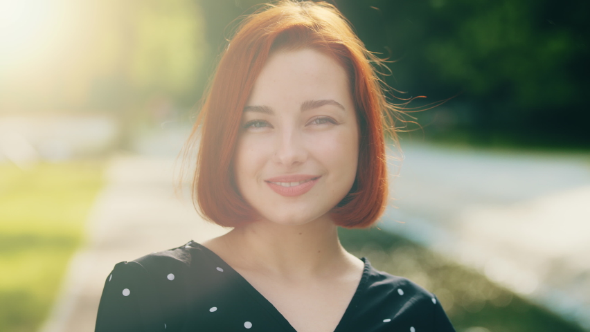 Portrait of happy attractive female face redhead stylish girl with short hairstyle smiling posing in city sunrays sends air kiss by hand gesture flirting demonstrating love sympathy feeling tenderness | Shutterstock HD Video #1091609285