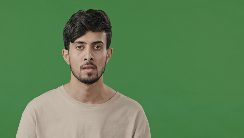Studio male portrait on green background young thoughtful arabic guy creator thinking pondering plan searching for solution amazed indian man coming up with idea finding answer raising index finger up | Shutterstock HD Video #1091609301