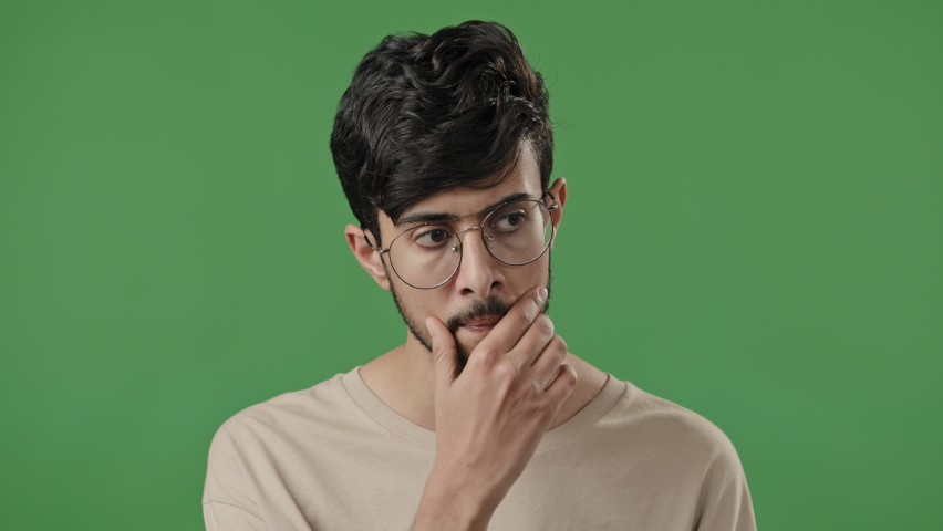 Clever arab man teacher in eyeglasses think hold hand on chin deep in thought indian guy student professor stand on green background fix spectacles generate idea dreaming smart face close-up portrait | Shutterstock HD Video #1091609311