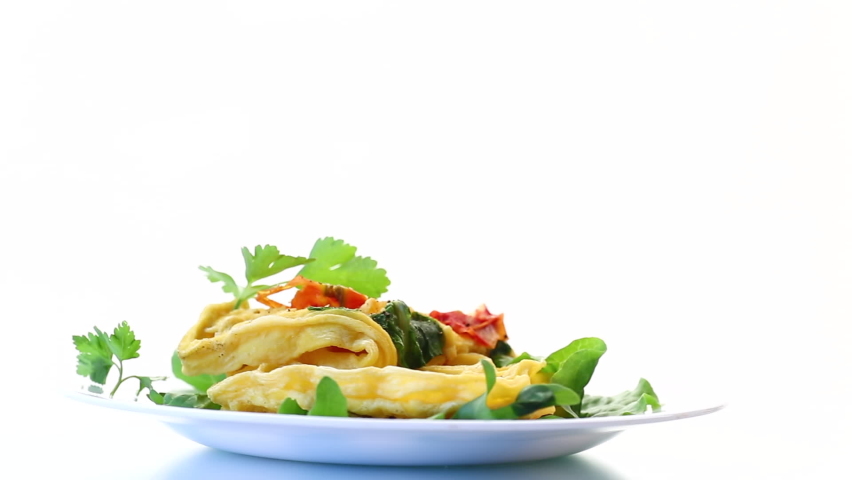 Egg omelet stuffed with tomato and greens fried in the form of waffles, isolated on white background