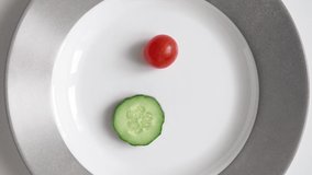 Vertical Video Man on diet eats little chili tomato and cucumber from plate. Concept slimming and healthy food. Natural ingredients. Vegetables and healthy eating. Portion control No animal byproducts
