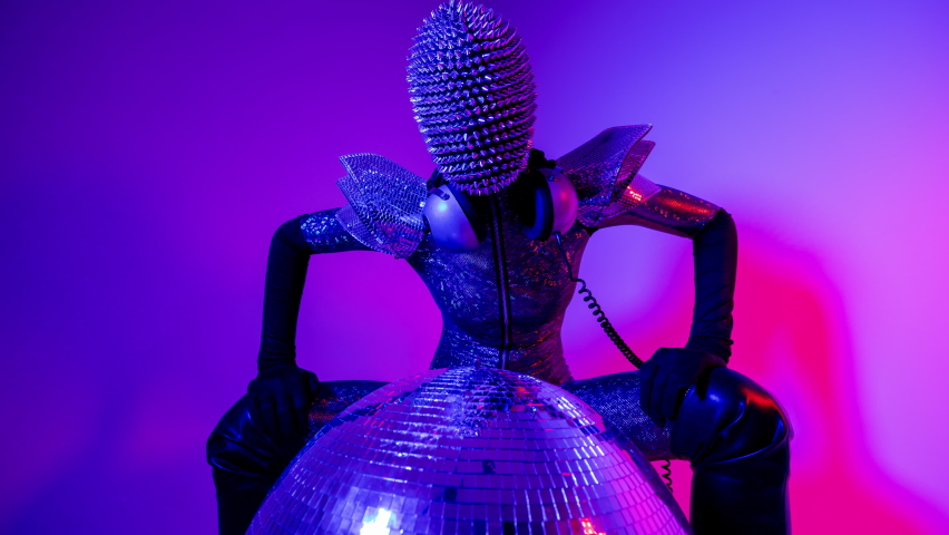 A disco dancer with spiky mask and silver costume against colourful background masquerade  | Shutterstock HD Video #1091612785