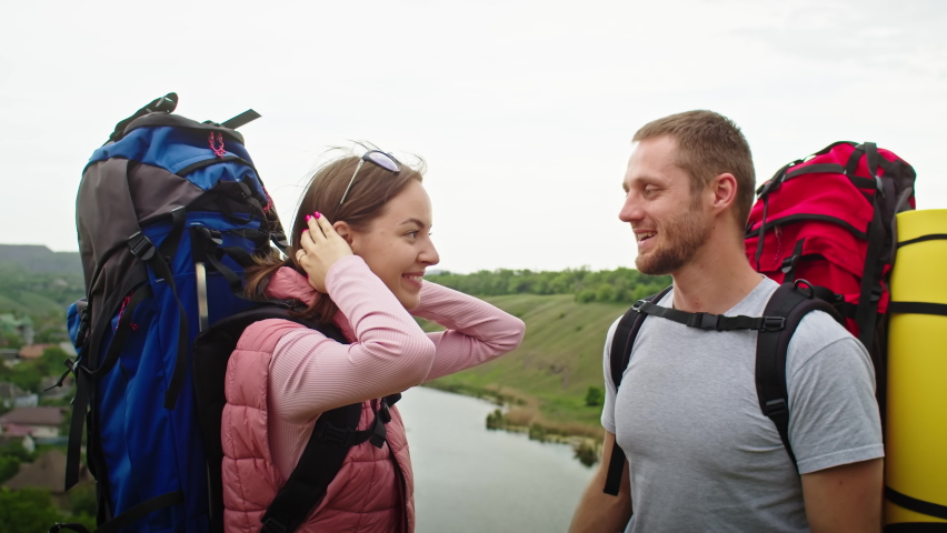 Happy couple, man and woman in the mountains, travel in search of a vacation spot. they rejoices, standing against the backdrop of a beautiful landscape. vacation in the mountains. | Shutterstock HD Video #1091616279