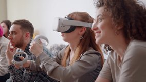 Exited woman in VR helmets at home. Friends in virtual reality headsets sitting on bed, playing video games and having fun together. 3D technology. concept of virtual reality, Gaming, friendship.