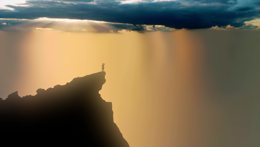 The sun's rays breaking through storm clouds and shining down on the silhouette of a person standing up high on a cliff edge. Royalty-Free Stock Footage #1091617437